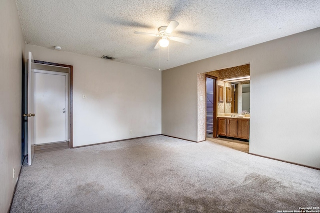 3030 Heidi St, San Antonio, TX 78247 - unfurnished bedroom featuring carpet flooring, a textured ceiling, ceiling fan, baseboards, and connected bathroom