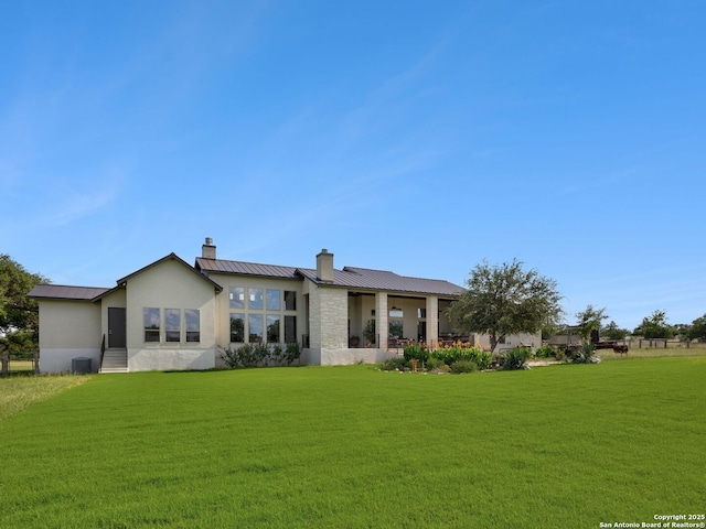 16 Taylor Rdg, Boerne, TX 78006 - back of property featuring a chimney, metal roof, a standing seam roof, a yard, and stone siding