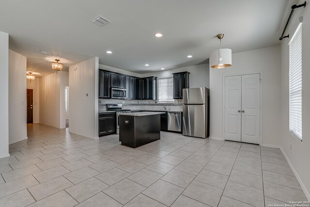 9910 Cowboy Ln, San Antonio, TX 78254 - kitchen with appliances with stainless steel finishes, dark cabinetry, light tile patterned floors, tasteful backsplash, and a center island