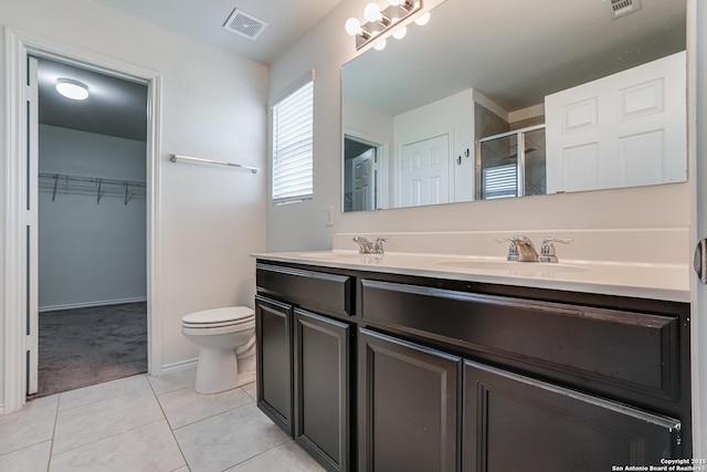 9910 Cowboy Ln, San Antonio, TX 78254 - bathroom with double vanity, a stall shower, tile patterned floors, toilet, and a spacious closet