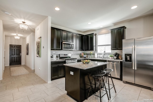 9910 Cowboy Ln, San Antonio, TX 78254 - kitchen with stainless steel appliances, backsplash, light stone countertops, a center island, and recessed lighting