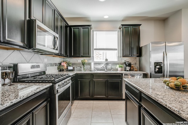 9910 Cowboy Ln, San Antonio, TX 78254 - kitchen with stainless steel appliances, a sink, light stone counters, backsplash, and light tile patterned floors