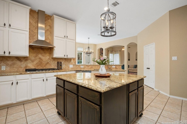 19426 Desert Oak, San Antonio, TX 78258 - kitchen featuring wall chimney range hood, a chandelier, stainless steel gas cooktop, decorative backsplash, and light tile patterned floors
