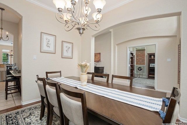 19426 Desert Oak, San Antonio, TX 78258 - dining area featuring a chandelier, arched walkways, ornamental molding, and wood finished floors