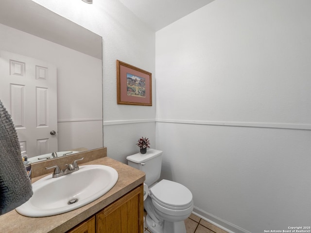 3842 Fiesta Trl, San Antonio, TX 78245 - half bathroom featuring toilet, vanity, tile patterned flooring, and baseboards