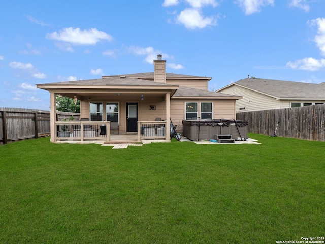 3842 Fiesta Trl, San Antonio, TX 78245 - rear view of property featuring a hot tub, a patio, and a chimney