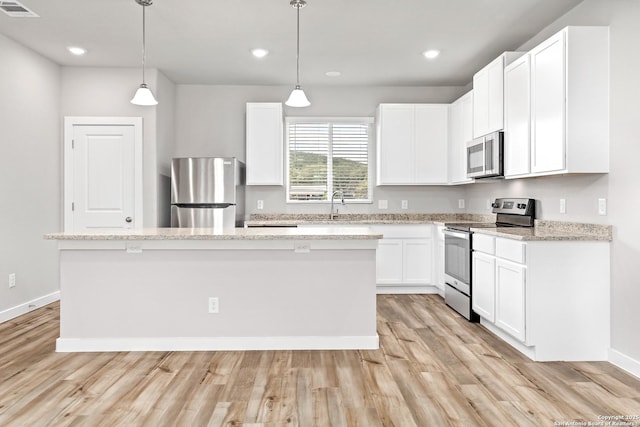 21535 Sir Walter, San Antonio, TX 78256 - kitchen featuring appliances with stainless steel finishes, a center island, light wood finished floors, white cabinetry, and recessed lighting