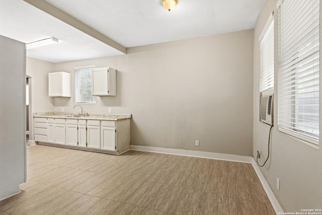 323 Roseborough, San Antonio, TX 78210 - kitchen with white cabinets, a sink, and baseboards