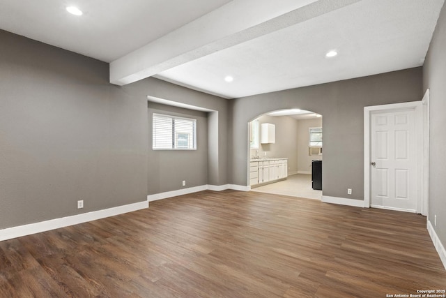 323 Roseborough, San Antonio, TX 78210 - unfurnished living room with arched walkways, wood finished floors, plenty of natural light, baseboards, and recessed lighting
