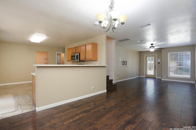 7 Brieley Ln, San Antonio, TX 78250 - kitchen featuring stainless steel microwave, light countertops, wood finished floors, a chandelier, and a peninsula