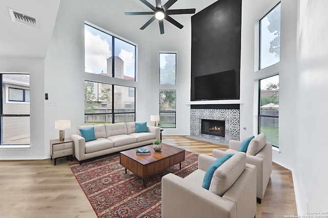 16415 Old Stable, San Antonio, TX 78247 - living area with a towering ceiling, ceiling fan, wood finished floors, a tiled fireplace, and baseboards