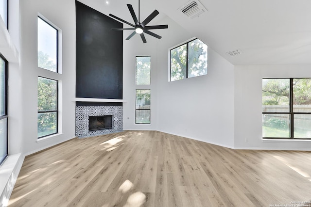 16415 Old Stable, San Antonio, TX 78247 - unfurnished living room with high vaulted ceiling, wood finished floors, a tiled fireplace, a ceiling fan, and baseboards