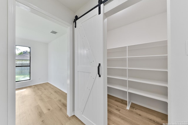 16415 Old Stable, San Antonio, TX 78247 - hallway with a barn door, wood finished floors, and baseboards