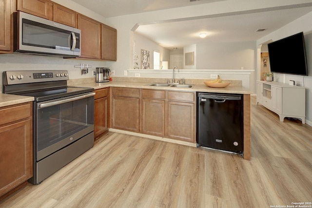 11907 Pure Silver, San Antonio, TX 78254 - kitchen with appliances with stainless steel finishes, a sink, a peninsula, light wood-type flooring, and light countertops