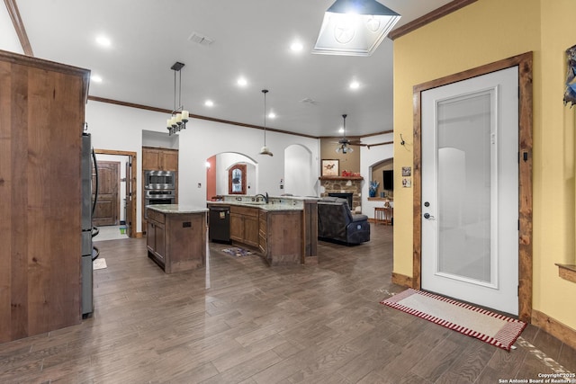 151 Native Pecan, Canyon Lake, TX 78133 - kitchen featuring stainless steel appliances, a kitchen island with sink, crown molding, arched walkways, and open floor plan