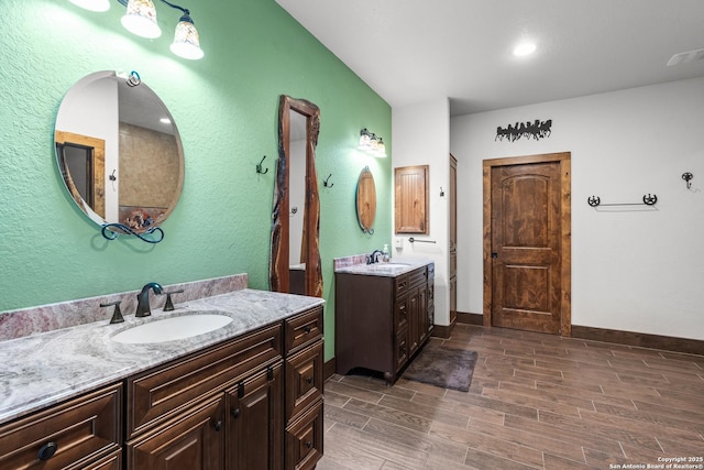 151 Native Pecan, Canyon Lake, TX 78133 - full bathroom featuring two vanities, wood tiled floors, and baseboards