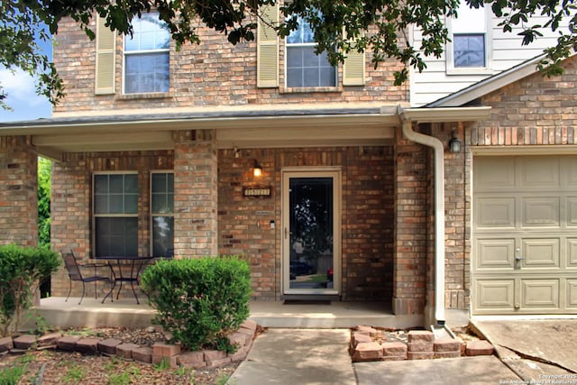 7527 Escada Crst, San Antonio, TX 78254 - view of exterior entry with covered porch, a garage, and brick siding
