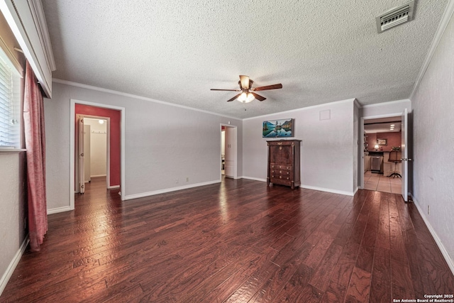 11 El Norte Cir, Uvalde, TX 78801 - unfurnished living room with ceiling fan, dark wood-style flooring, crown molding, a textured ceiling, and baseboards