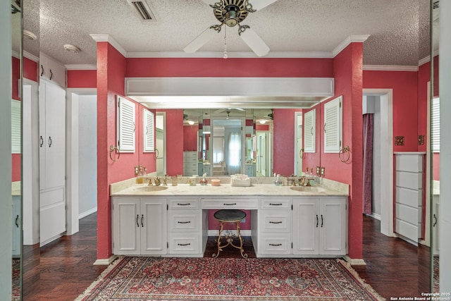11 El Norte Cir, Uvalde, TX 78801 - bathroom featuring a ceiling fan, double vanity, a textured ceiling, wood finished floors, and baseboards