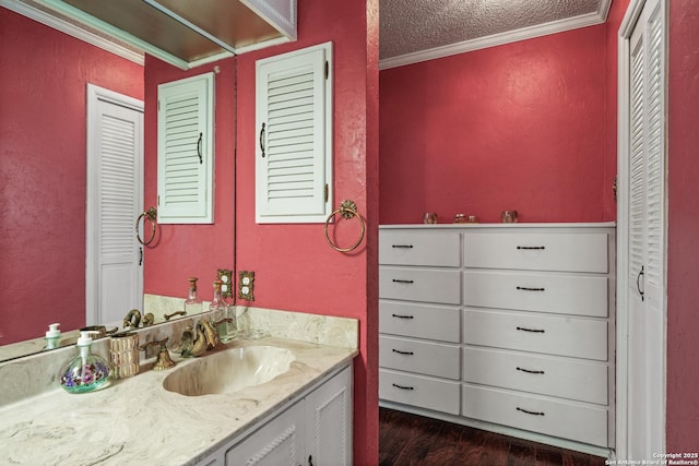 11 El Norte Cir, Uvalde, TX 78801 - bathroom with vanity, ornamental molding, a closet, wood finished floors, and a textured wall