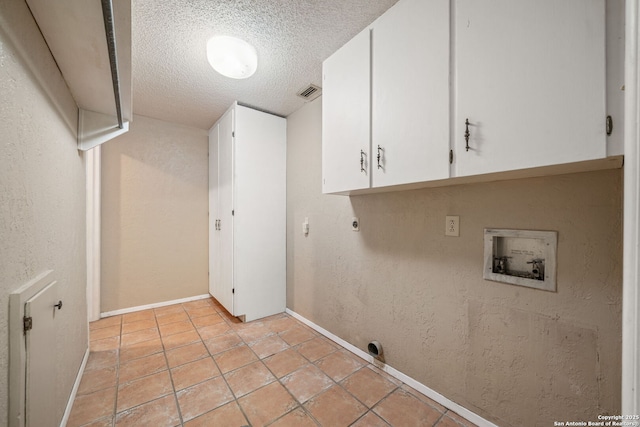 11 El Norte Cir, Uvalde, TX 78801 - laundry area with hookup for an electric dryer, cabinet space, a textured ceiling, washer hookup, and baseboards