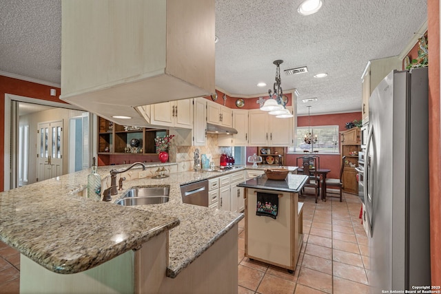 11 El Norte Cir, Uvalde, TX 78801 - kitchen featuring appliances with stainless steel finishes, a textured ceiling, a sink, a peninsula, and a center island