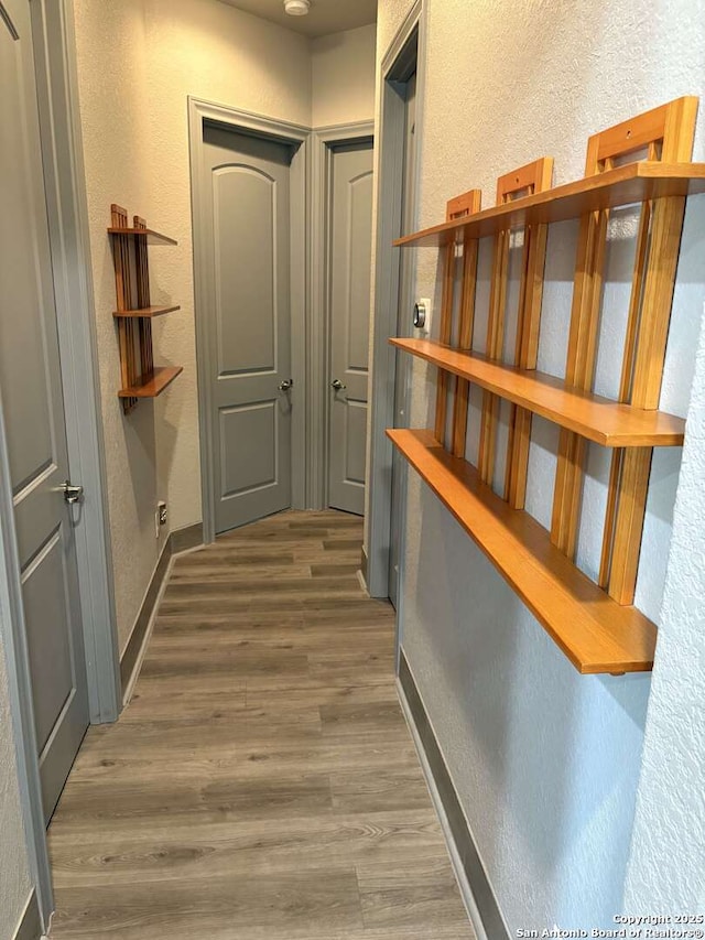 636 Carriage House # 30, Spring Branch, TX 78070 - hallway featuring a textured wall, wood finished floors, and baseboards