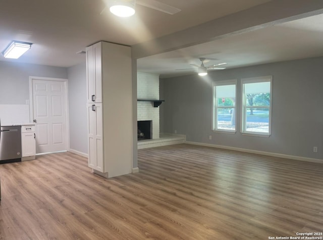 3002 Wroxton, San Antonio, TX 78217 - unfurnished living room featuring a ceiling fan, light wood-type flooring, baseboards, and a fireplace