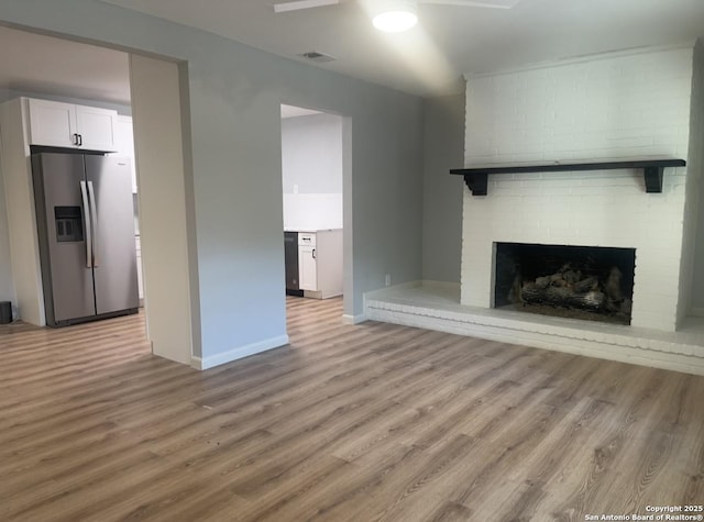 3002 Wroxton, San Antonio, TX 78217 - unfurnished living room with light wood-style floors, baseboards, a fireplace, and ceiling fan
