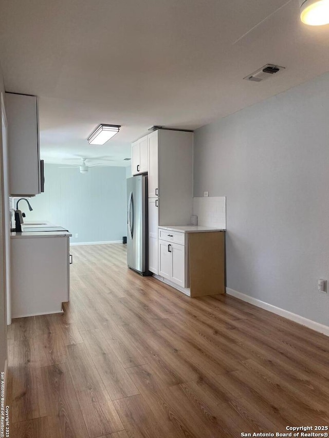 3002 Wroxton, San Antonio, TX 78217 - kitchen featuring freestanding refrigerator, light wood-type flooring, a sink, and baseboards