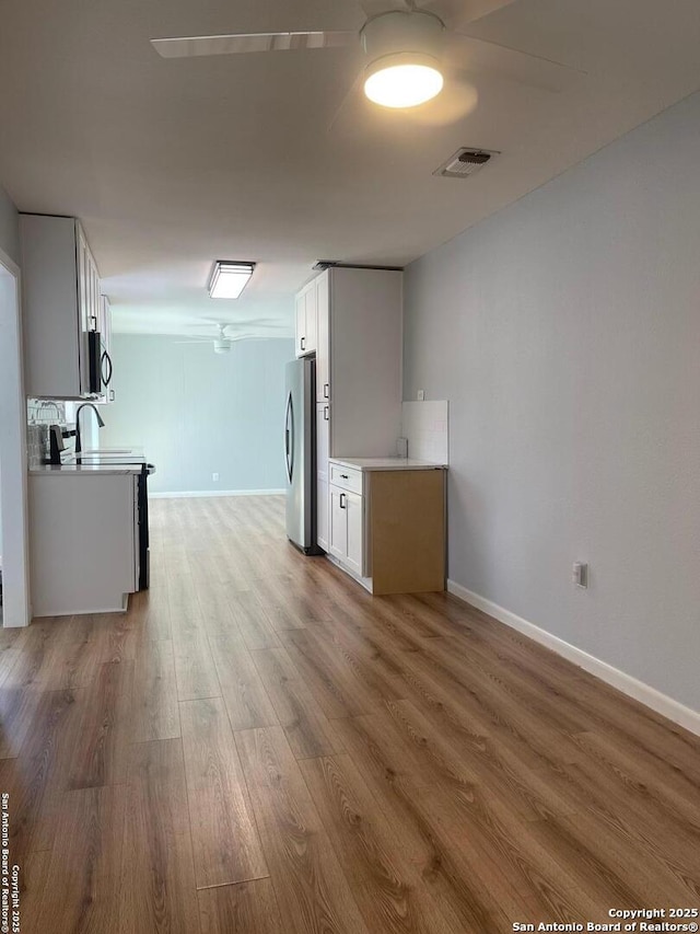 3002 Wroxton, San Antonio, TX 78217 - unfurnished living room featuring light wood-type flooring, baseboards, and a ceiling fan