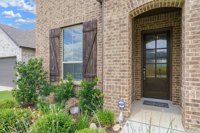 1524 Leeds Park, Bulverde, TX 78163 - view of exterior entry with brick siding, an attached garage, and a shingled roof