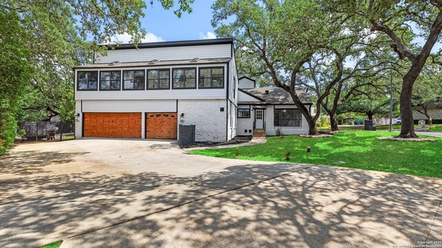 1818 Moreshead, San Antonio, TX 78231 - view of front facade featuring a garage, driveway, and brick siding
