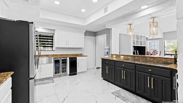 1818 Moreshead, San Antonio, TX 78231 - kitchen with freestanding refrigerator, dark cabinetry, beverage cooler, white cabinetry, and hanging light fixtures