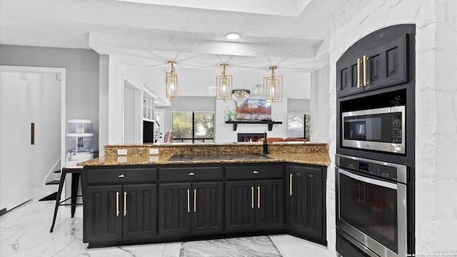 1818 Moreshead, San Antonio, TX 78231 - kitchen featuring stainless steel appliances, dark cabinets, light stone counters, light marble finish floors, and a textured ceiling