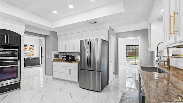 1818 Moreshead, San Antonio, TX 78231 - kitchen with appliances with stainless steel finishes, a textured ceiling, white cabinets, baseboards, and light marble finish flooring