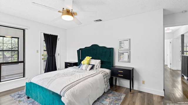 1818 Moreshead, San Antonio, TX 78231 - bedroom featuring a textured ceiling, wood finished floors, multiple windows, baseboards, and ceiling fan