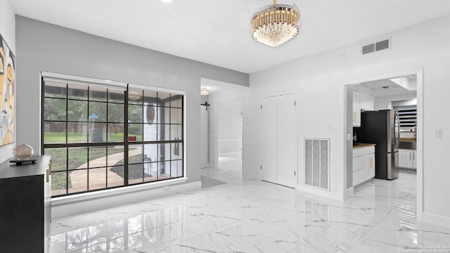 1818 Moreshead, San Antonio, TX 78231 - spare room with light marble finish flooring, a chandelier, baseboards, and a textured ceiling