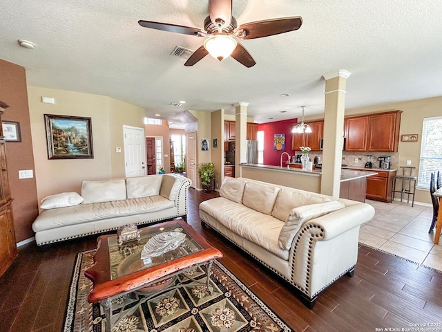 1031 Starlit Pond, San Antonio, TX 78260 - living room featuring ornate columns, a ceiling fan, wood finished floors, and a textured ceiling