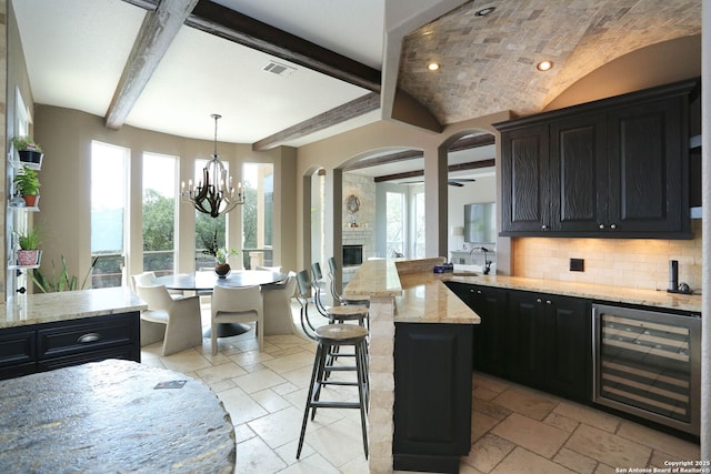 1818 Palmer Vw, San Antonio, TX 78260 - kitchen featuring beverage cooler, stone tile flooring, a fireplace, decorative backsplash, and a breakfast bar area