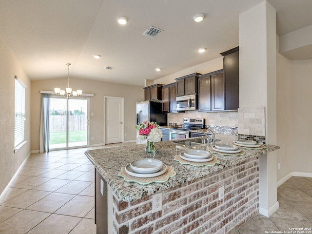 2325 Lighthouse, New Braunfels, TX 78130 - kitchen featuring stainless steel appliances, light stone counters, a chandelier, dark brown cabinets, and baseboards