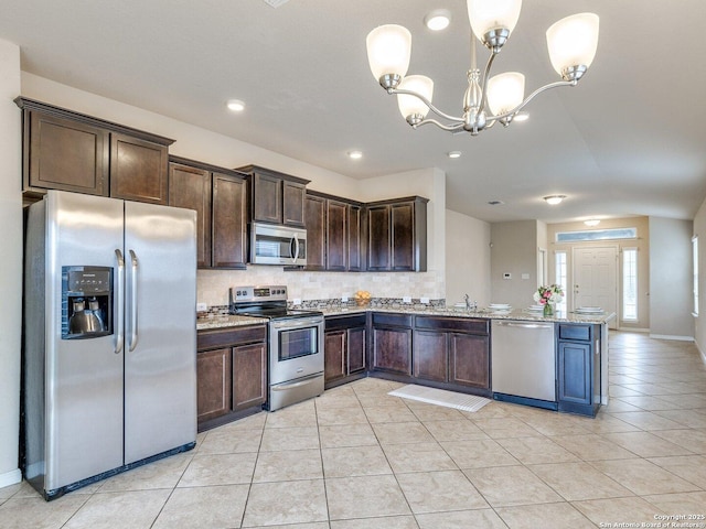 2325 Lighthouse, New Braunfels, TX 78130 - kitchen with stainless steel appliances, dark brown cabinetry, tasteful backsplash, a peninsula, and recessed lighting