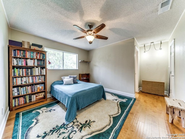 6802 S Forest Hvn, San Antonio, TX 78240 - bedroom with wood finished floors, a textured ceiling, baseboards, and a ceiling fan