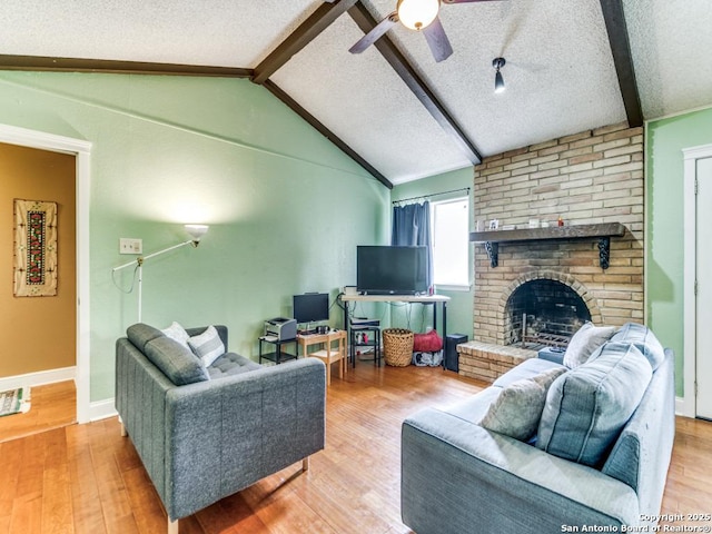 6802 S Forest Hvn, San Antonio, TX 78240 - living room featuring a textured ceiling, a ceiling fan, a brick fireplace, wood finished floors, and baseboards