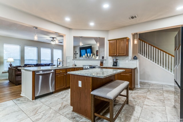 1342 Pinnacle, San Antonio, TX 78260 - kitchen featuring stainless steel appliances, a sink, brown cabinetry, a kitchen island, and recessed lighting
