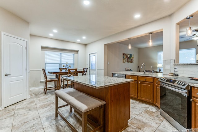 1342 Pinnacle, San Antonio, TX 78260 - kitchen featuring appliances with stainless steel finishes, brown cabinets, a sink, light stone countertops, and a kitchen bar