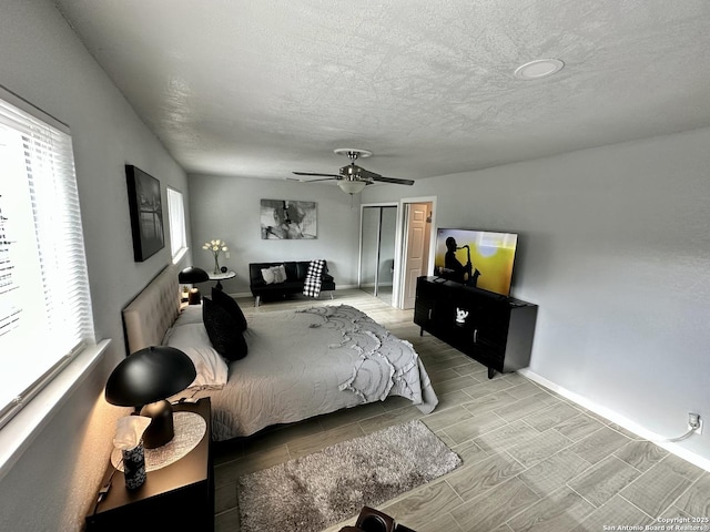 6422 Balky St, San Antonio, TX 78240 - bedroom featuring multiple windows, wood finish floors, baseboards, ceiling fan, and a textured ceiling