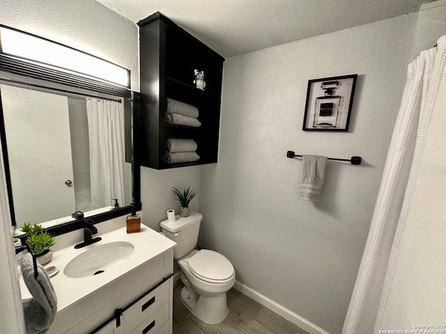 6422 Balky St, San Antonio, TX 78240 - bathroom featuring vanity, toilet, baseboards, a shower with curtain, and wood finished floors