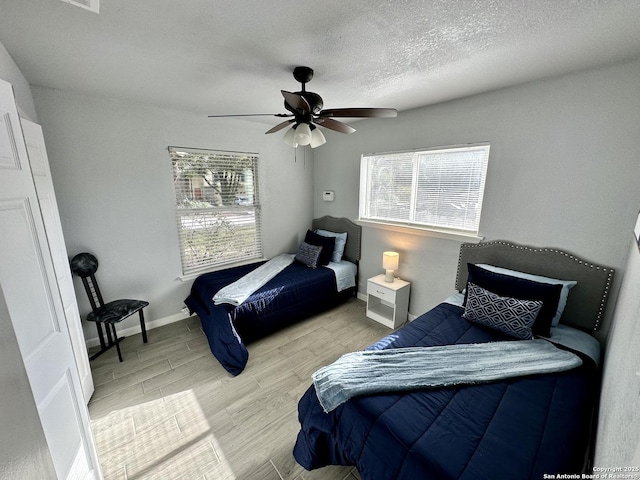6422 Balky St, San Antonio, TX 78240 - bedroom featuring wood finished floors, a ceiling fan, a textured ceiling, and baseboards