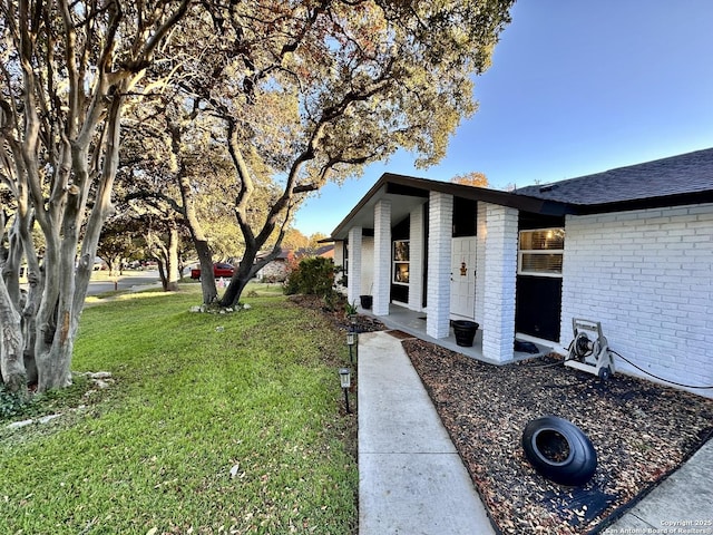 6422 Balky St, San Antonio, TX 78240 - view of side of property with a yard, brick siding, and roof with shingles